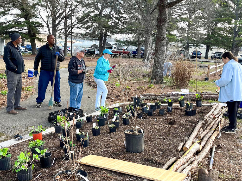 A small group of people work in a landscape.