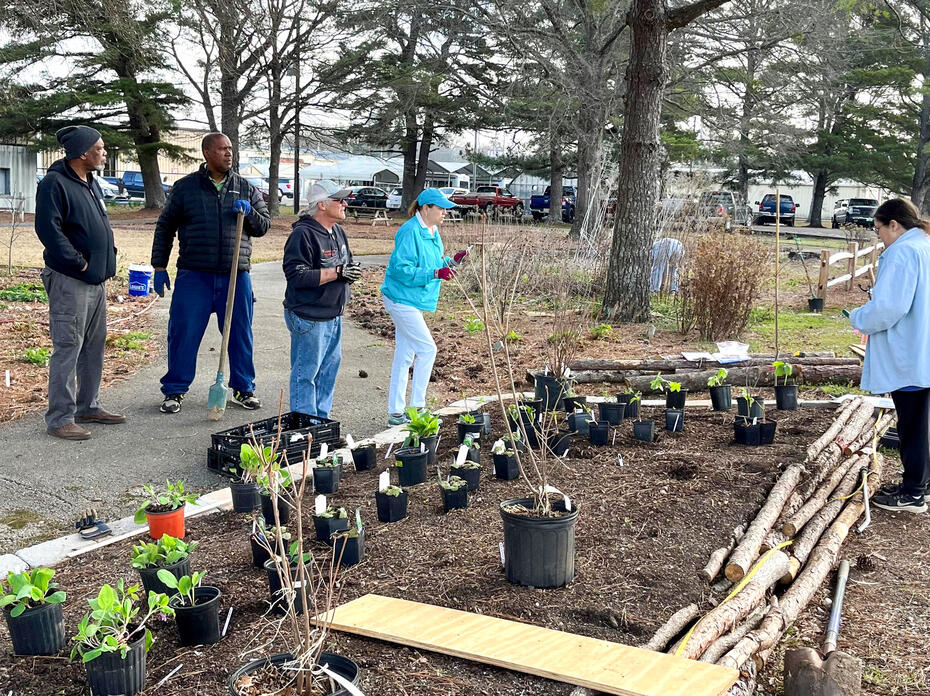 A small group of people work in a landscape.