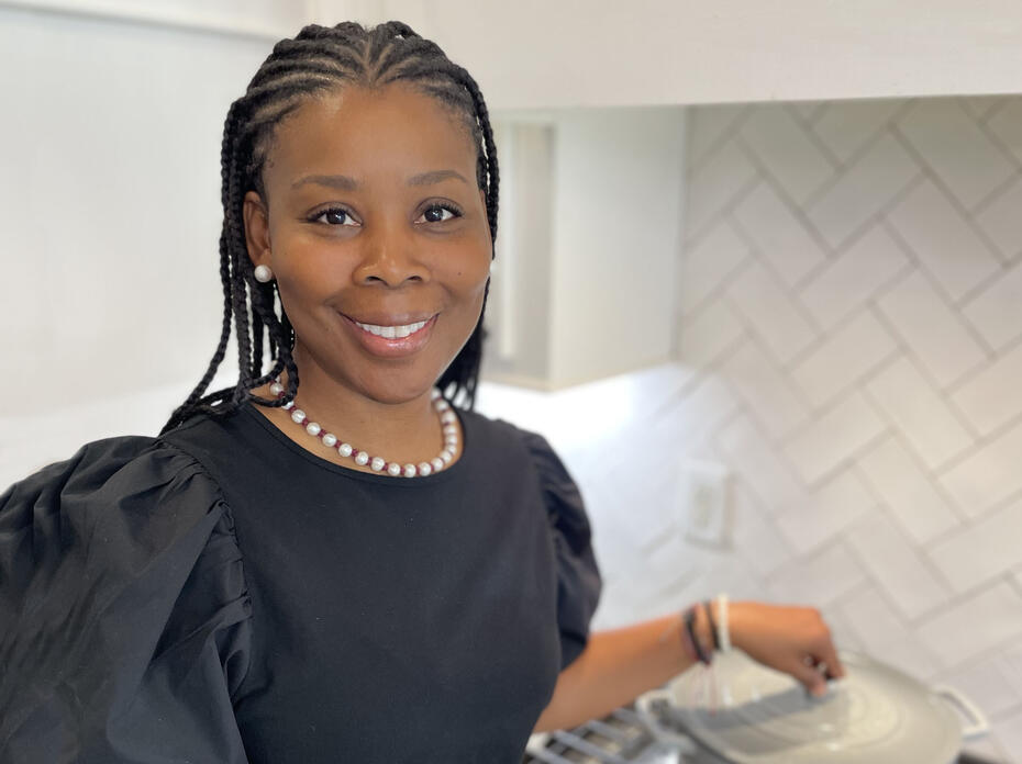 A woman stands in a kitchen.
