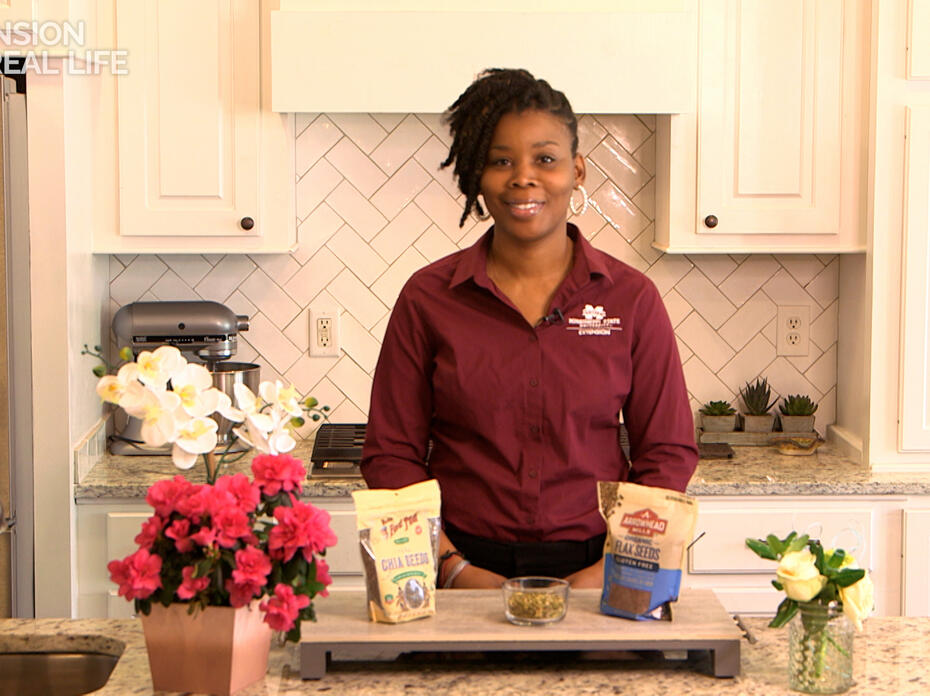 A woman stands at a kitchen counter.