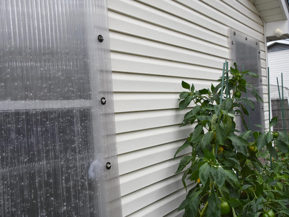 A clear panel covers a window on the exterior of a house.