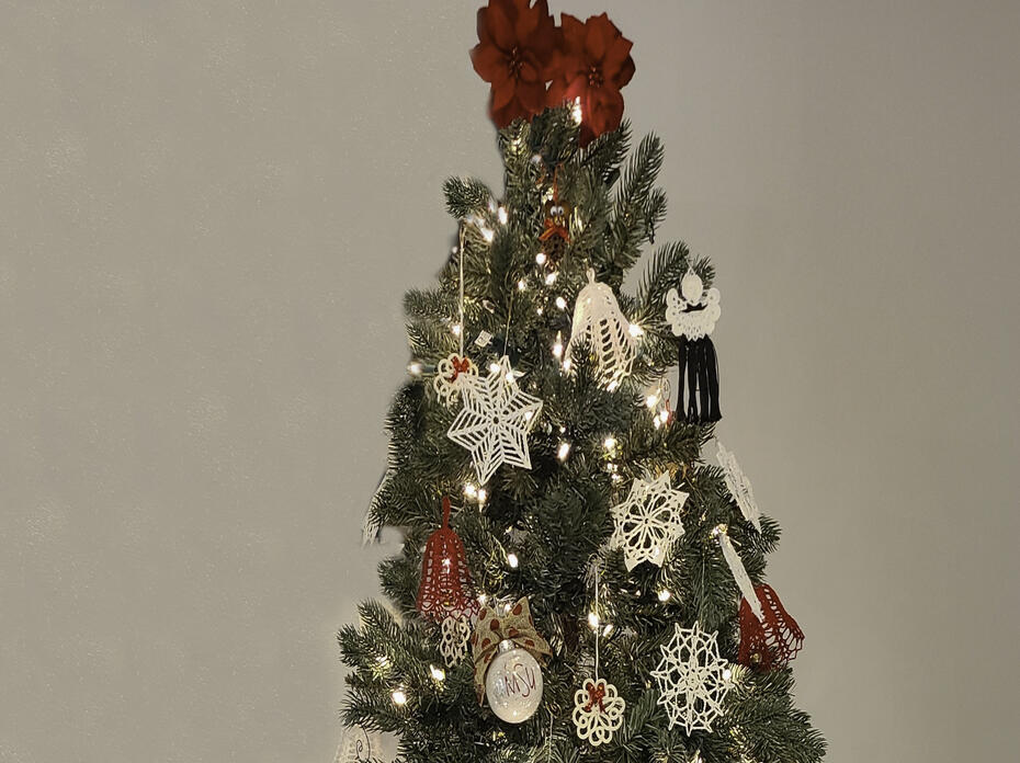 A Christmas tree is hung with red and white ornaments.