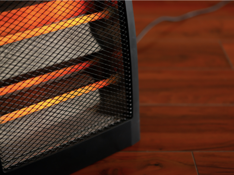 Close up of a space heater sitting on a hardwood floor