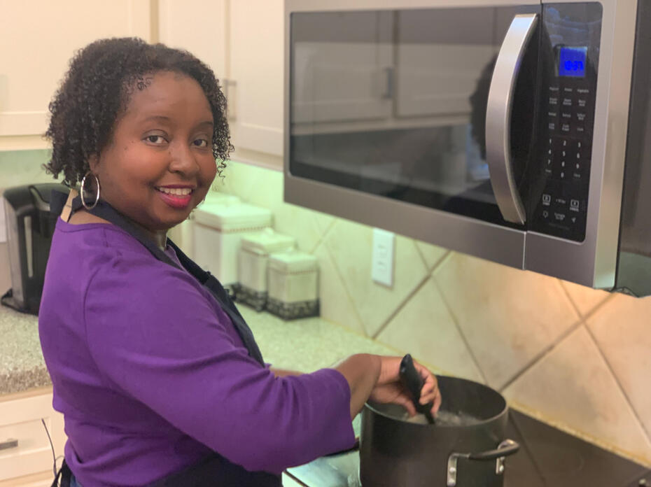 A woman stirs a pot of soup.