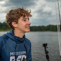A young person smiles out over the water.