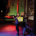 Two teenage girls holding cameras and yellow posters.