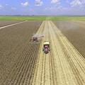 A combine and tractor in the center of a corn field