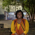 Shandrea Jenkins sitting on a brick planter.