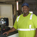 Steven Bell stands beside a truck housing a mosquito sprayer.