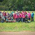 A large group of adults and children gathered on a grassy plain.