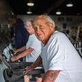 A smiling person walking on a treadmill.