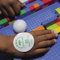 A child uses colorful LEGO bricks at a 4-H Robotics competition.