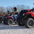 Several men on ATVs lined up.