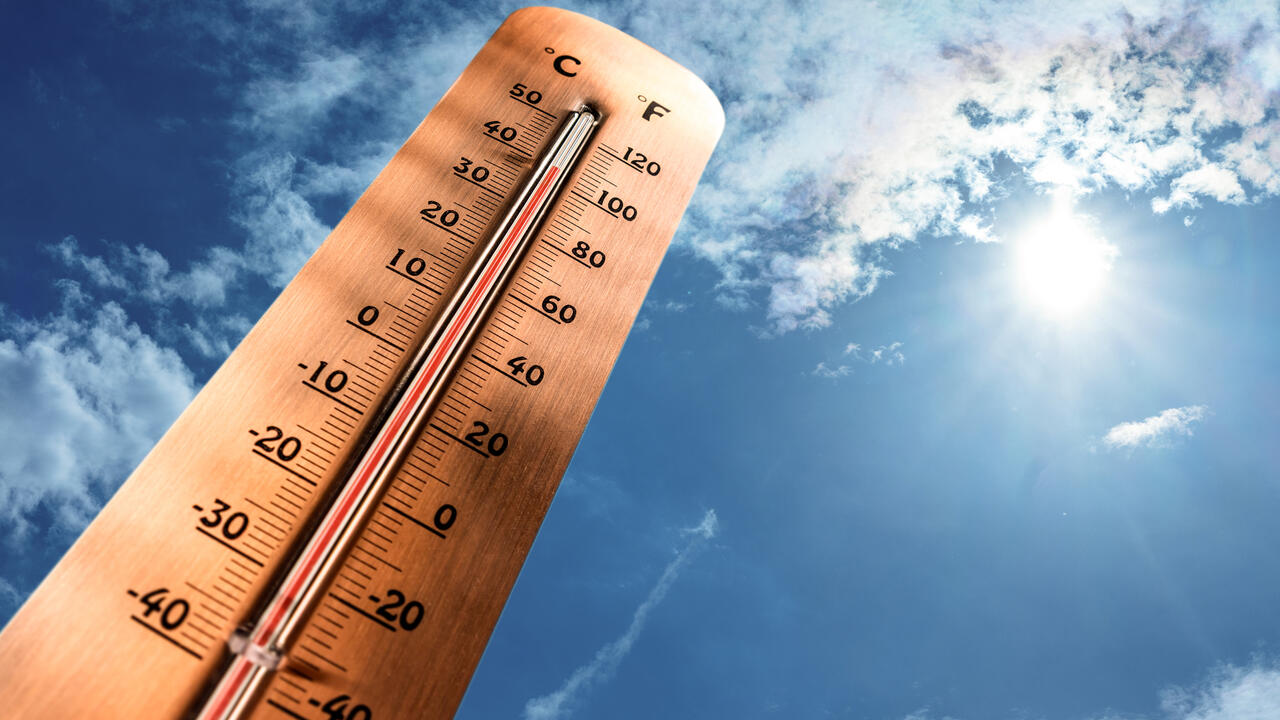 Thermometer facing the sky with a reading of 100 degrees F.