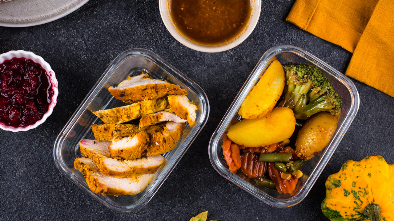 To-go containers of food and sauces on a table