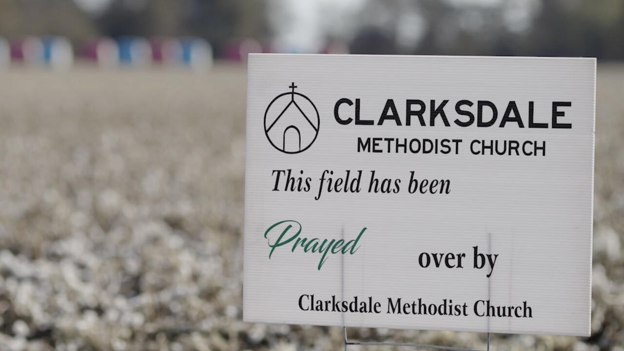 A small, white sign stands in field displaying the words, “This field has been prayed over by Clarksdale Methodist Church.”