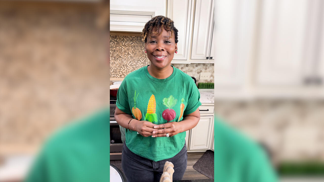 A woman stands in a kitchen.