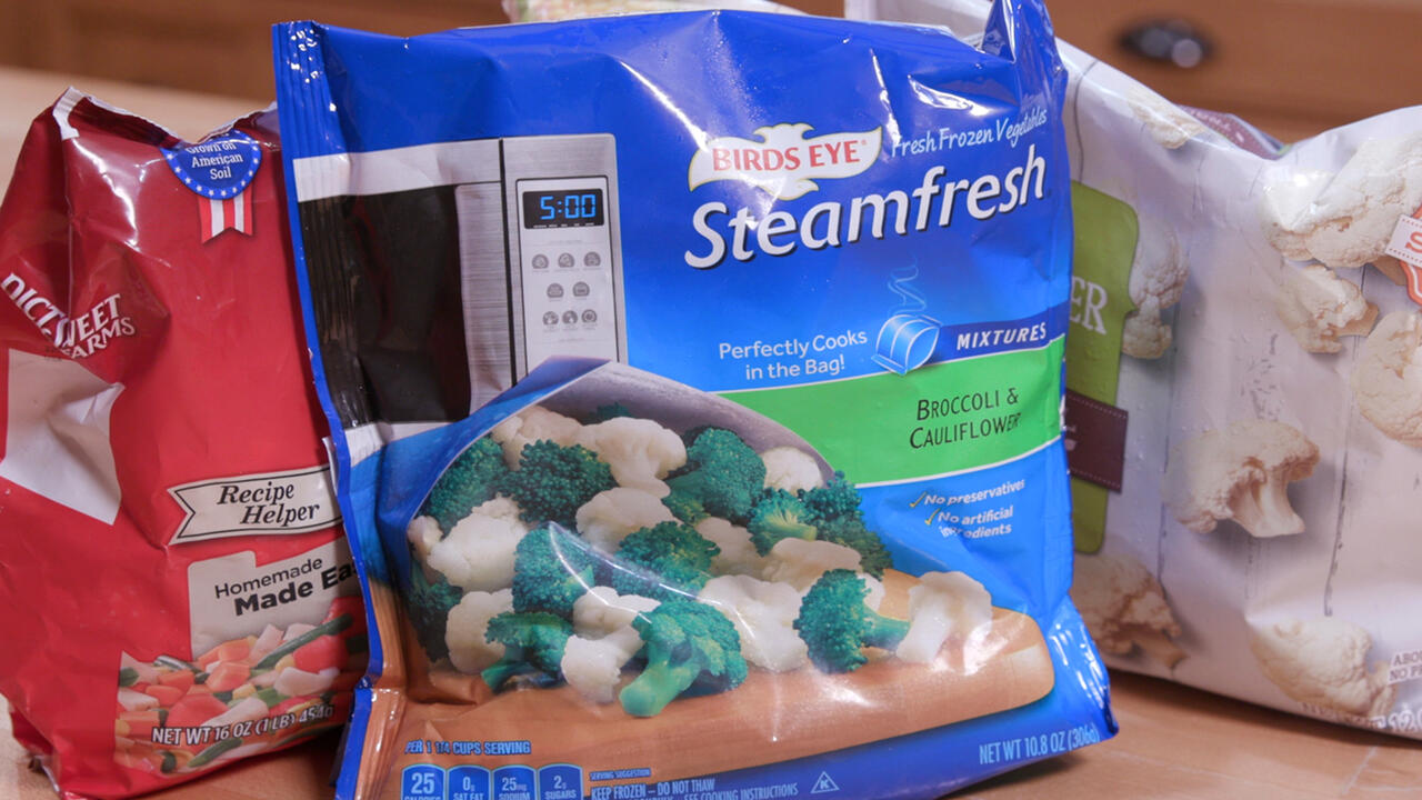 Three bags of frozen vegetables sit on a counter.