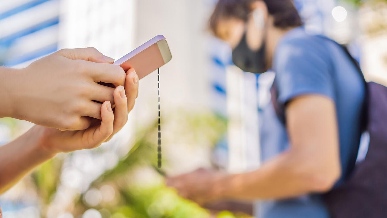 People wearing face masks holding cell phones