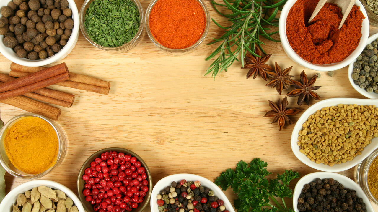 Closeup of herbs and spices on a cutting board.