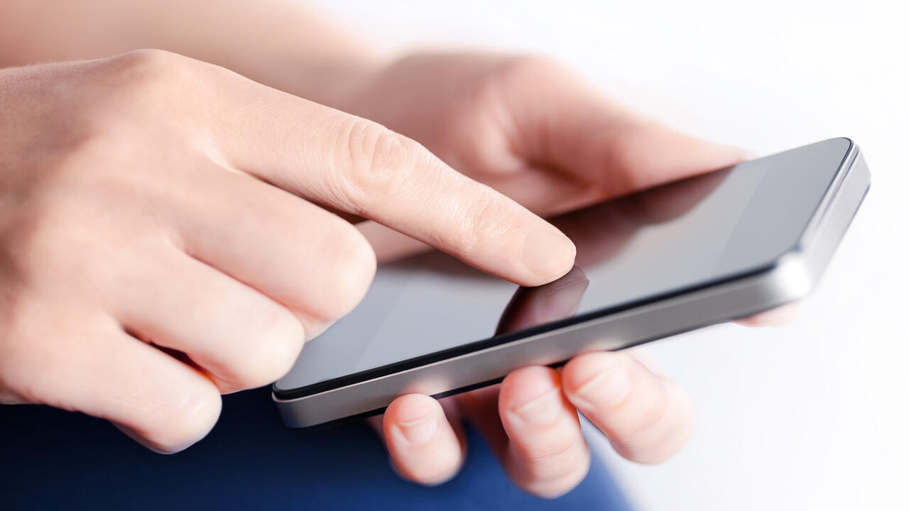 Hands holding a mobile phone.