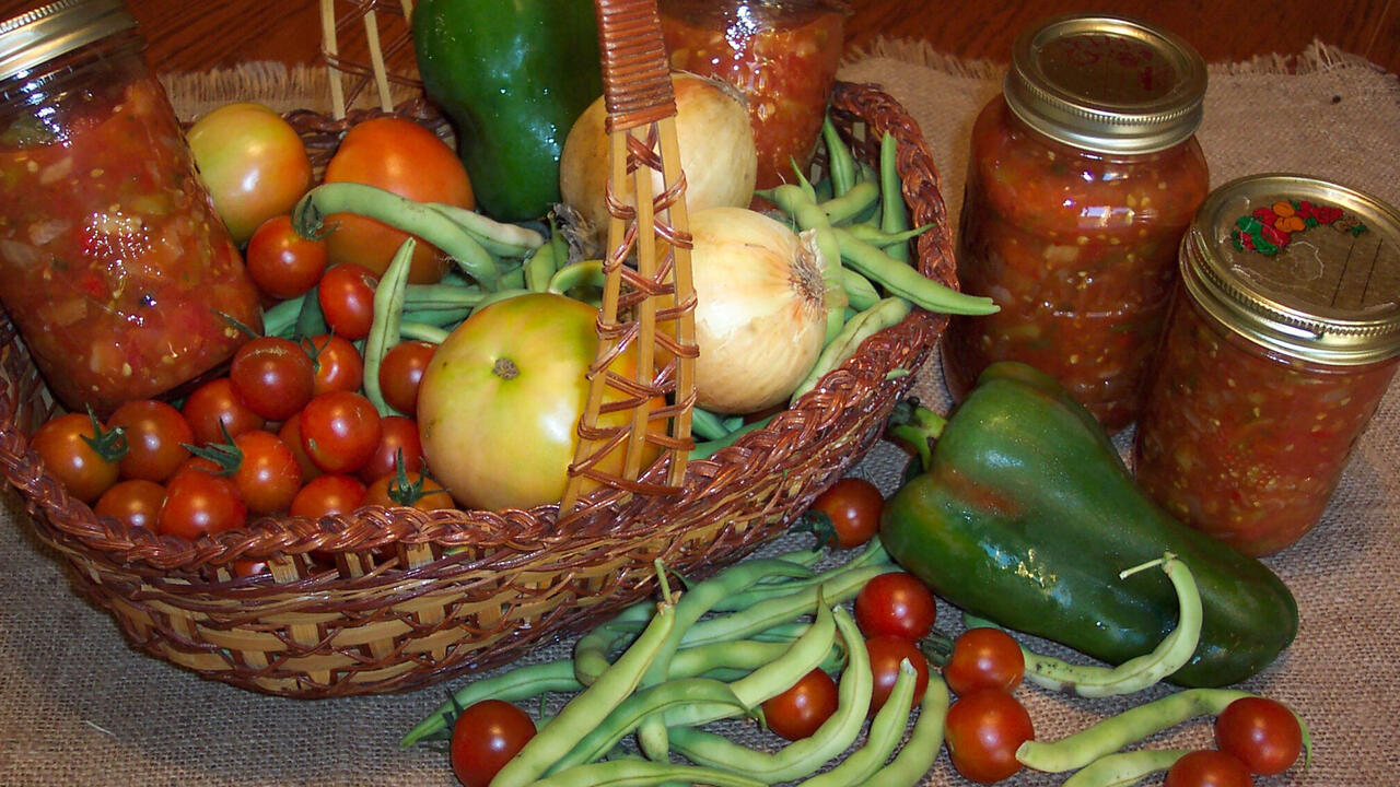 Canned salsa in a basket with other produce