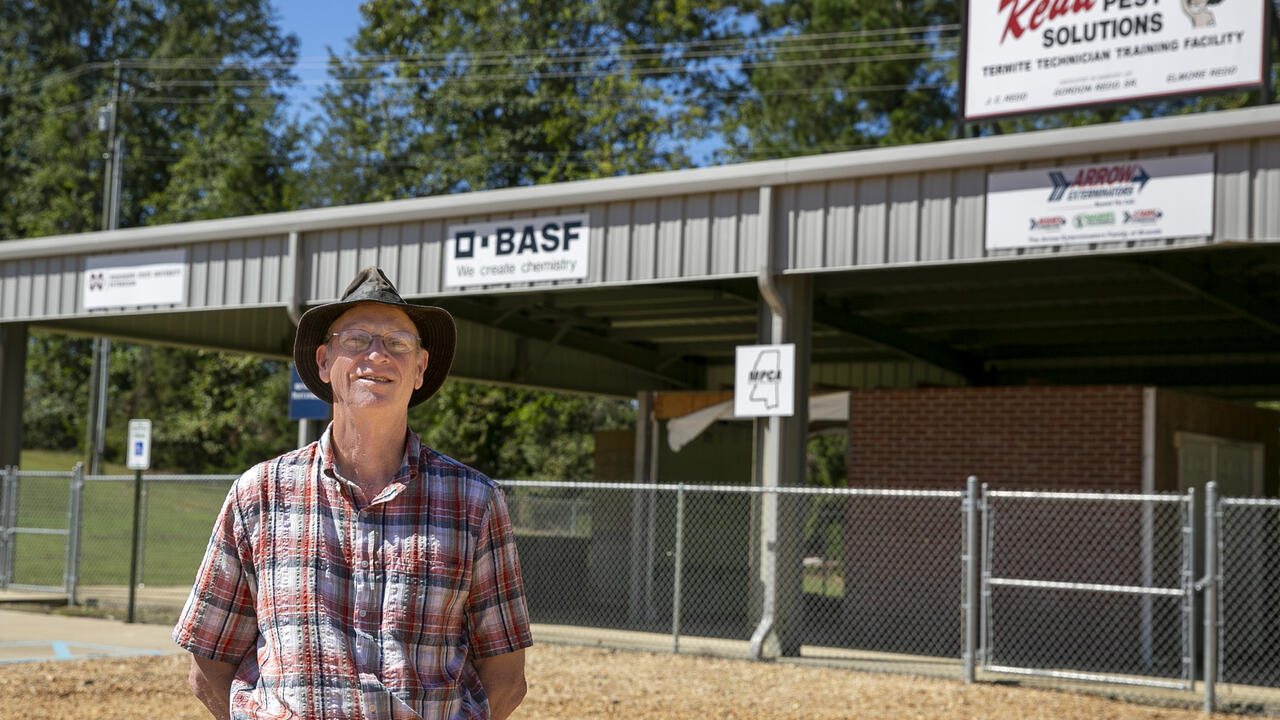 A man stands outside a structure.