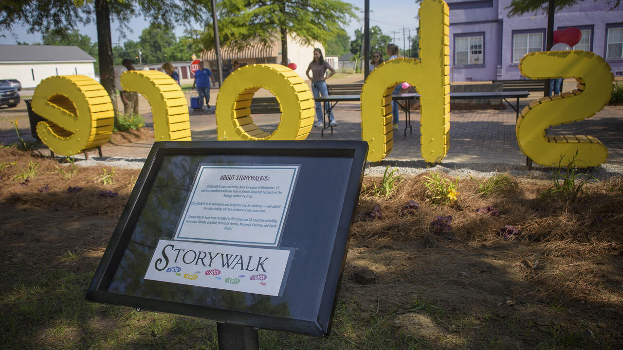 Yellow letters stand in the background behind a marker post.