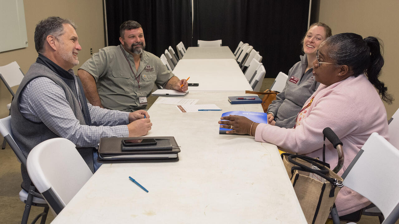 Four people at a table talking to each other.