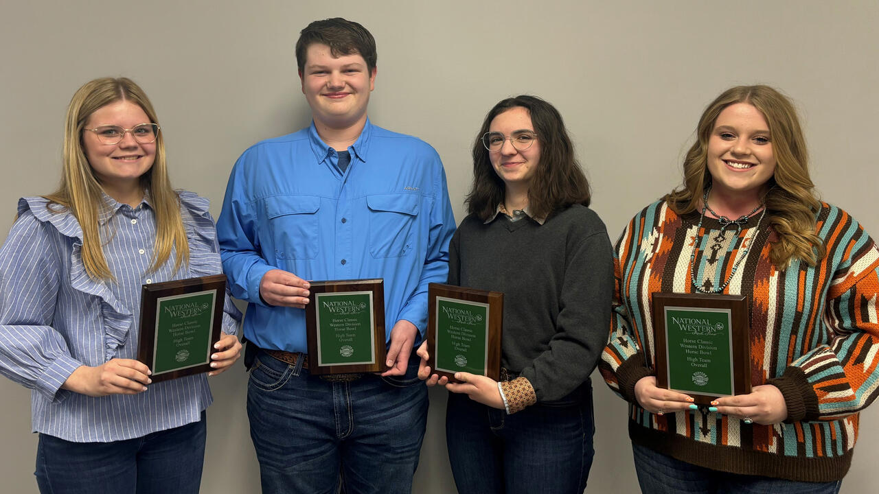 Four teenagers hold plaques.