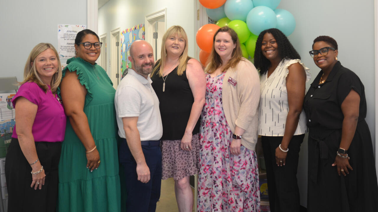 People pose for a photo during an open house event.