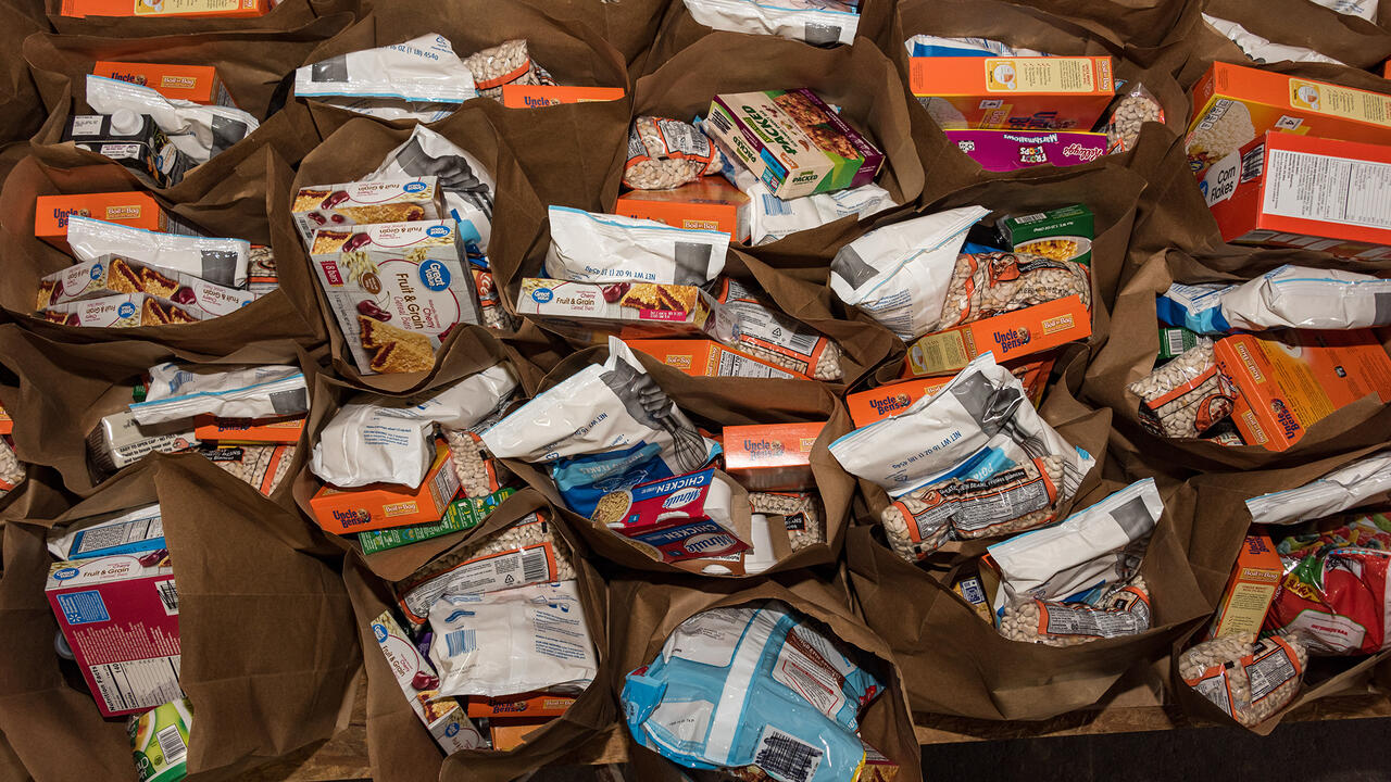 An assortment of food items inside paper grocery bags