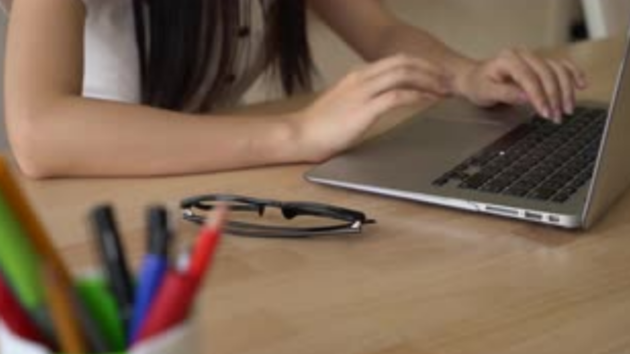 Hands typing on laptop keyboard