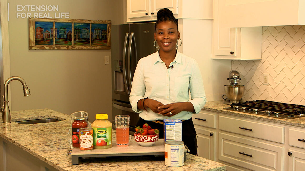 A woman stands in a kitchen with food products on the counter.