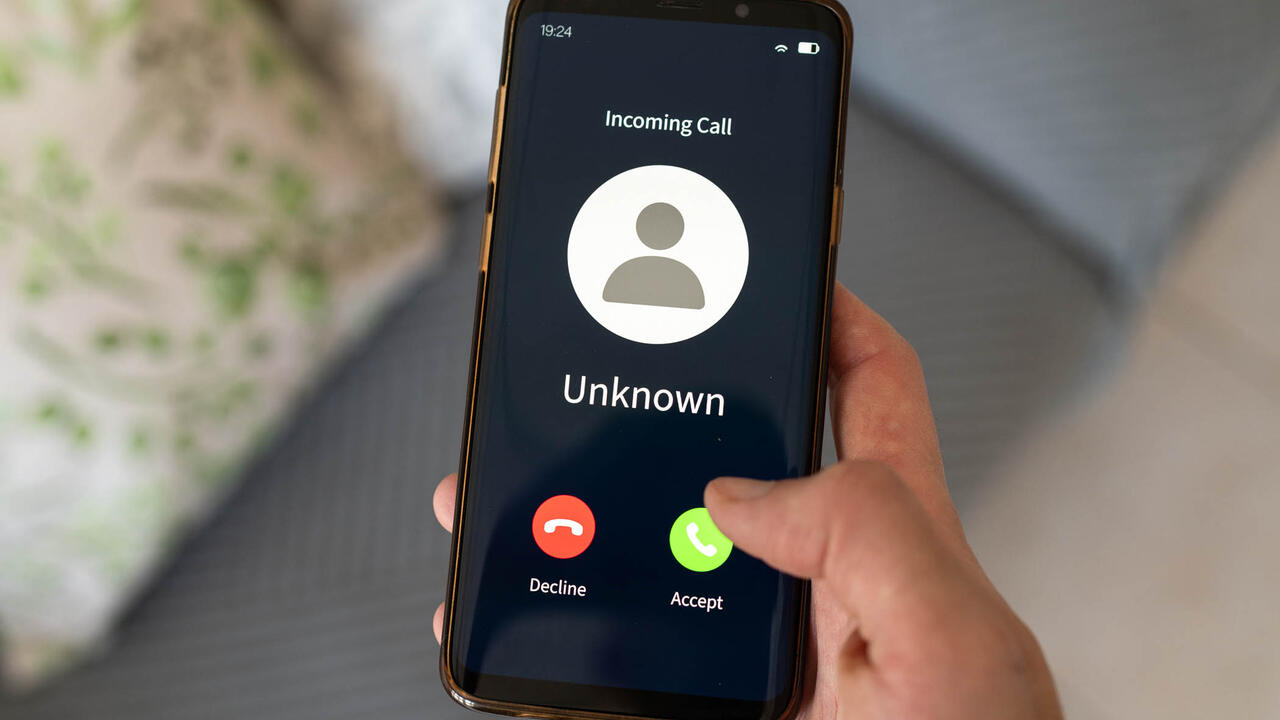 Concept of an imcoming call from an unknown number. Hand holding a cell phone.