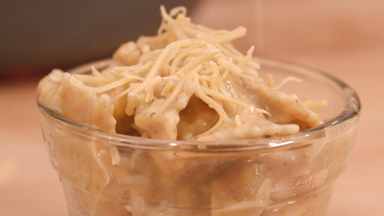 Butternut macaroni and cheese in a clear glass bowl.