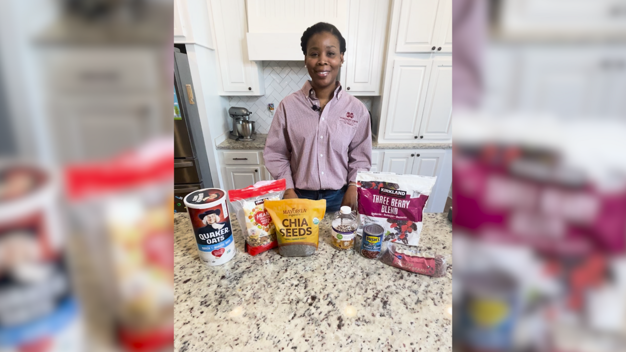 A woman stands in a kitchen with high-fiber foods on the counter.