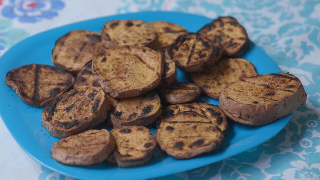 Grilled sweet potato slices on a bright turquoise blue plate
