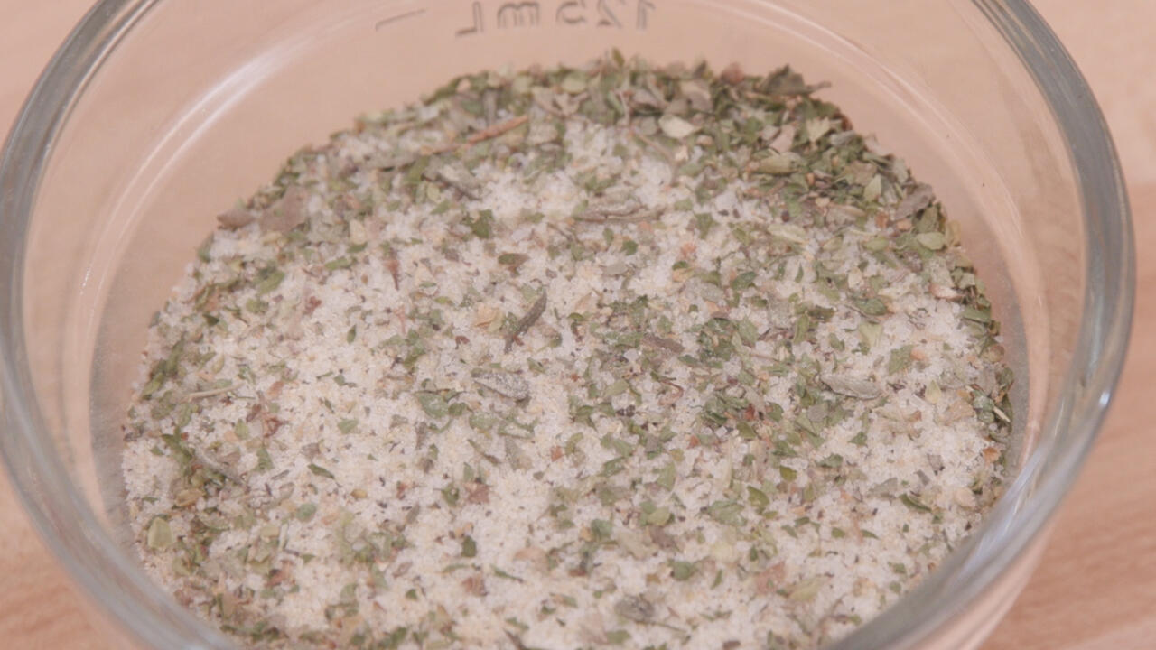 A mixture of spices and salt in a clear glass bowl
