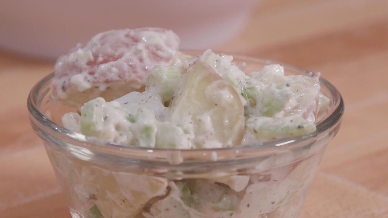 Potato salad in a small clear glass bowl