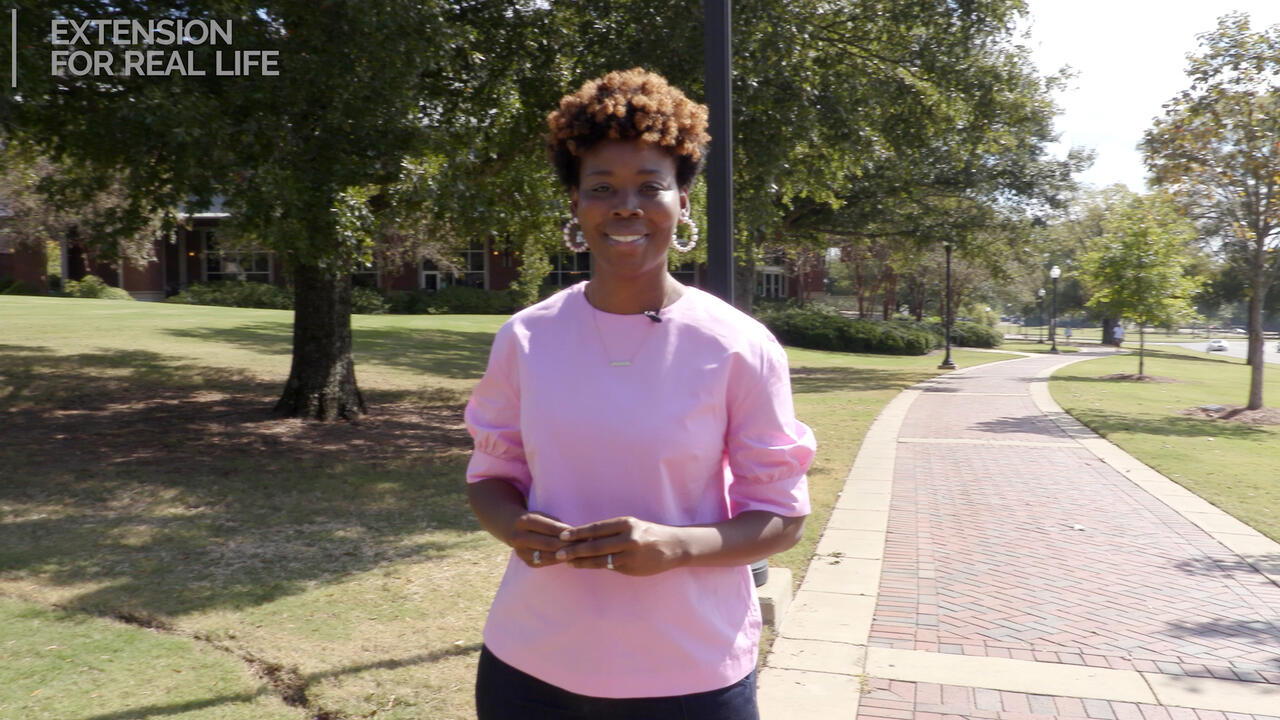 A woman stands on a sidewalk.