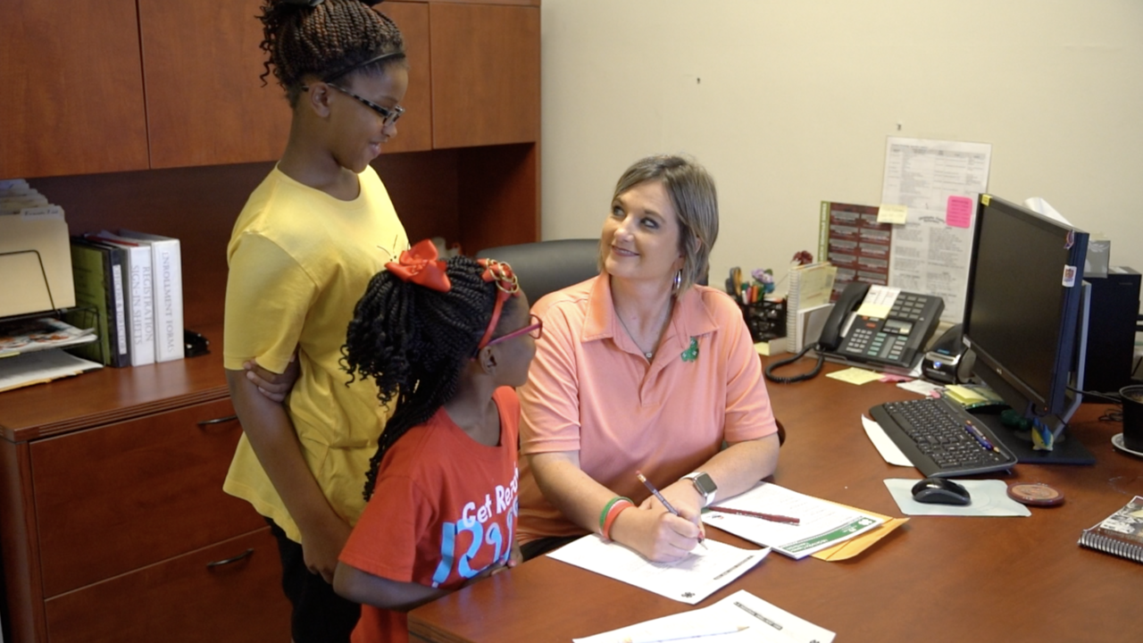 Woman filling out paper work with two children.