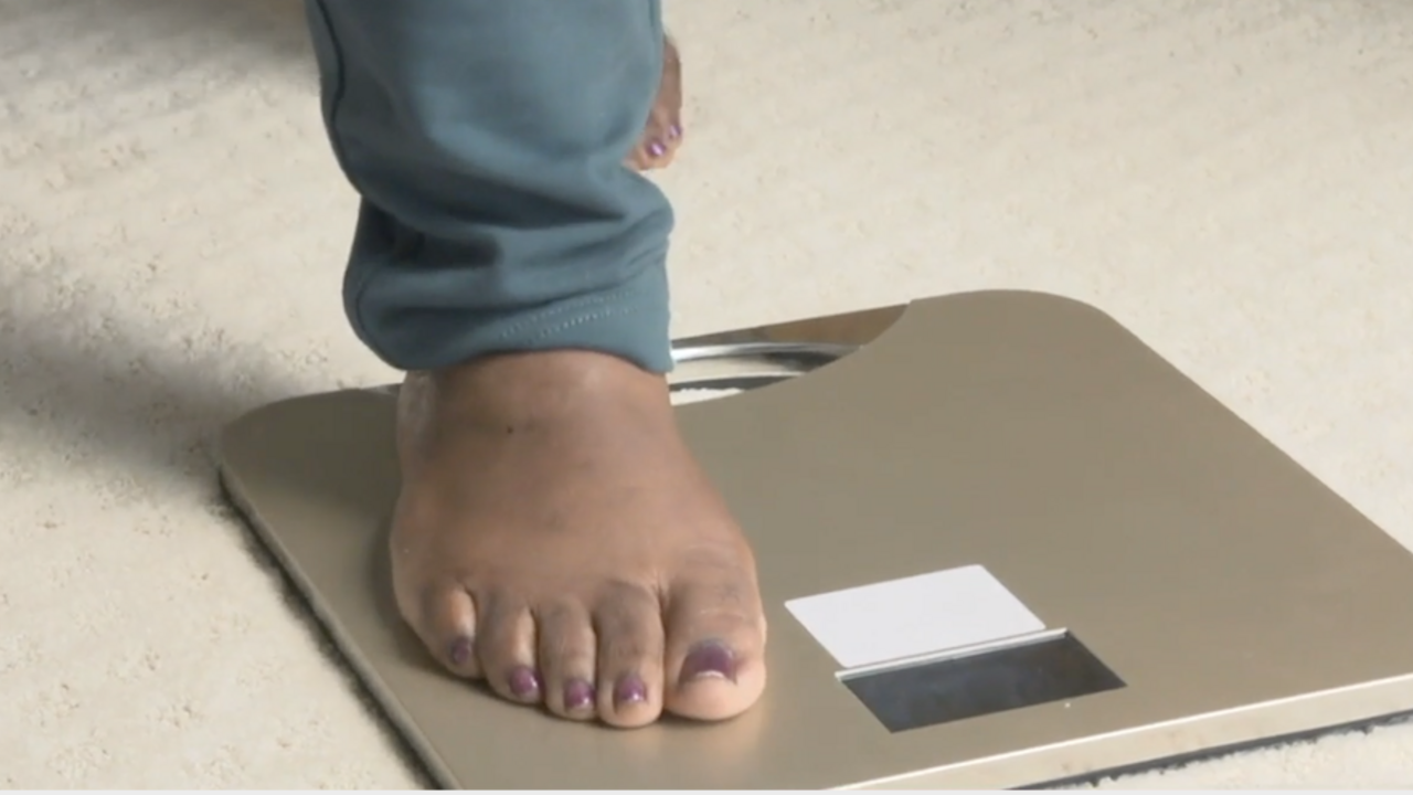 A close up picture of a person's foot stepping on a scale.