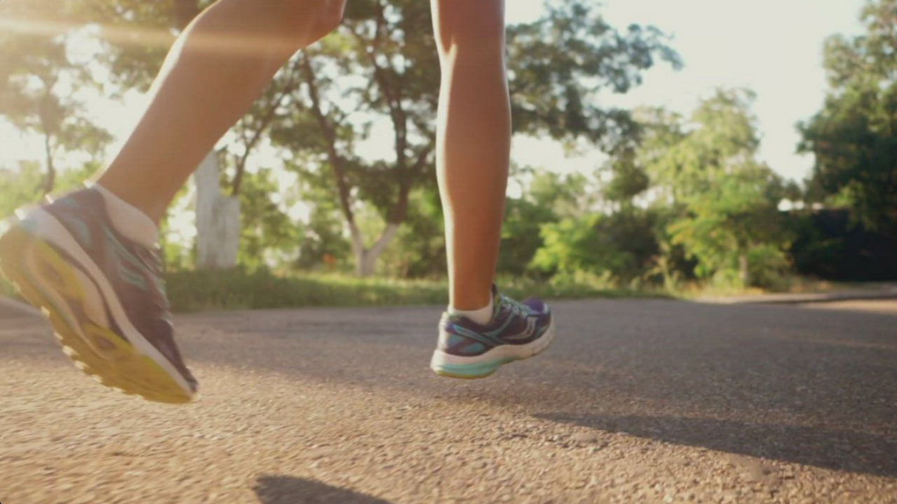 A person running with purple tennis shoes on.