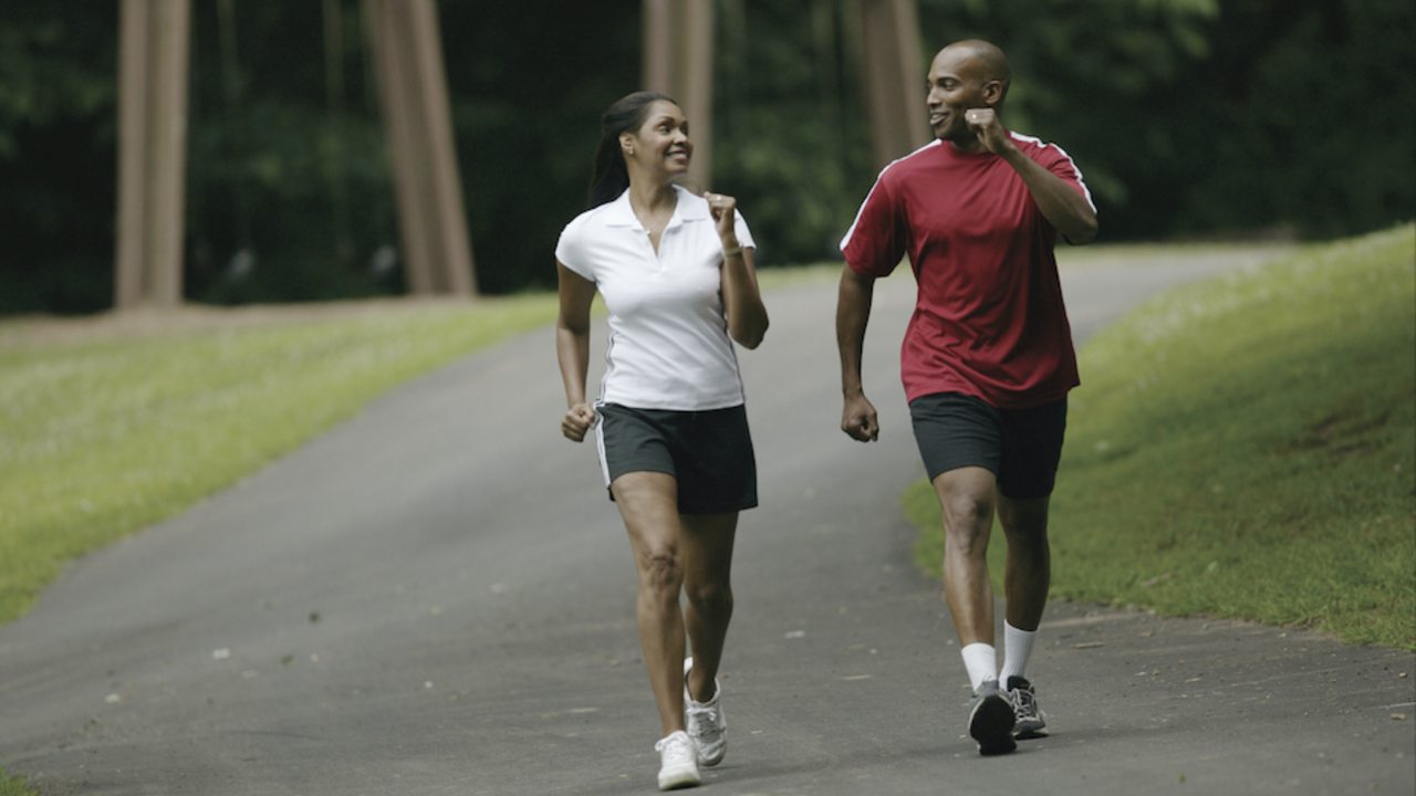 A woman and man walk for exercise.