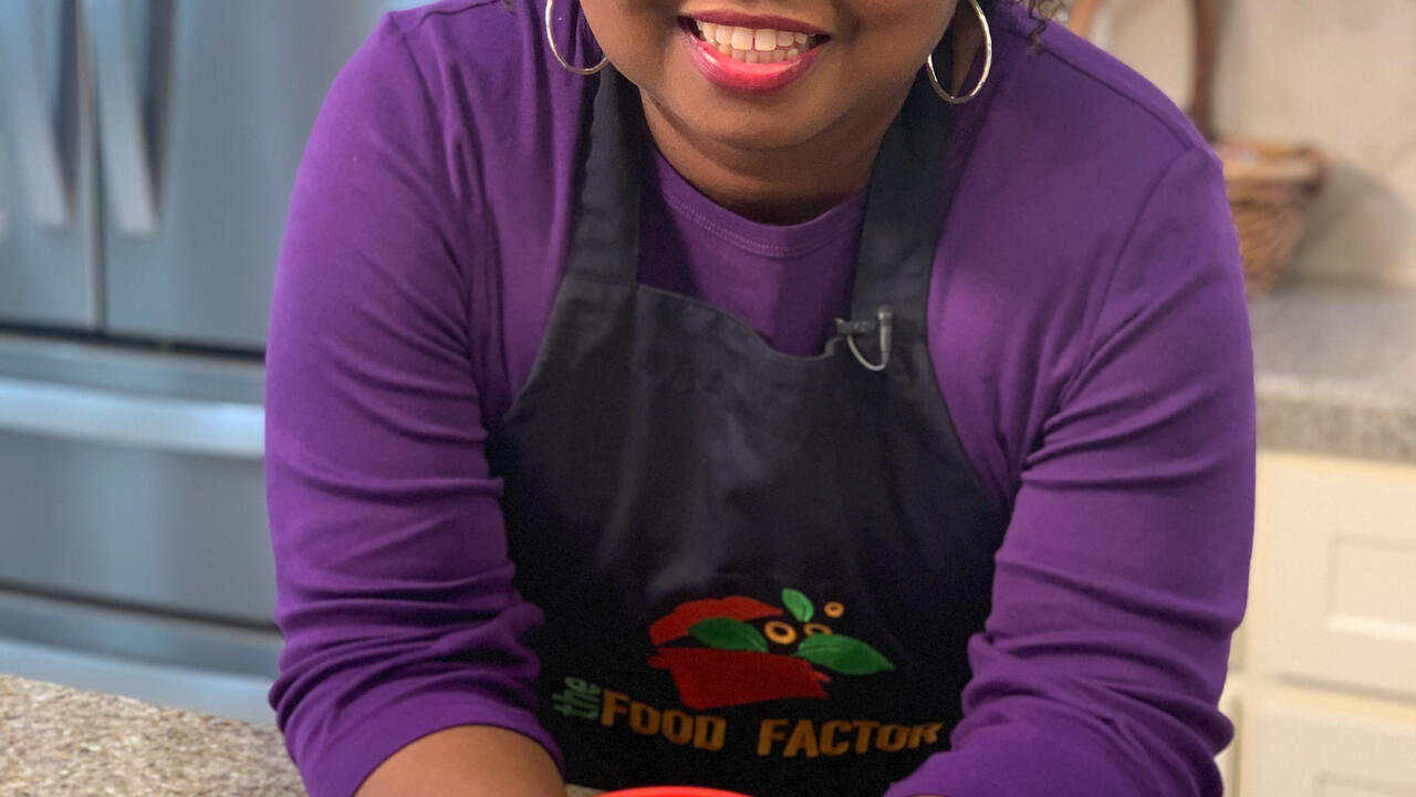 A woman stands in a kitchen.