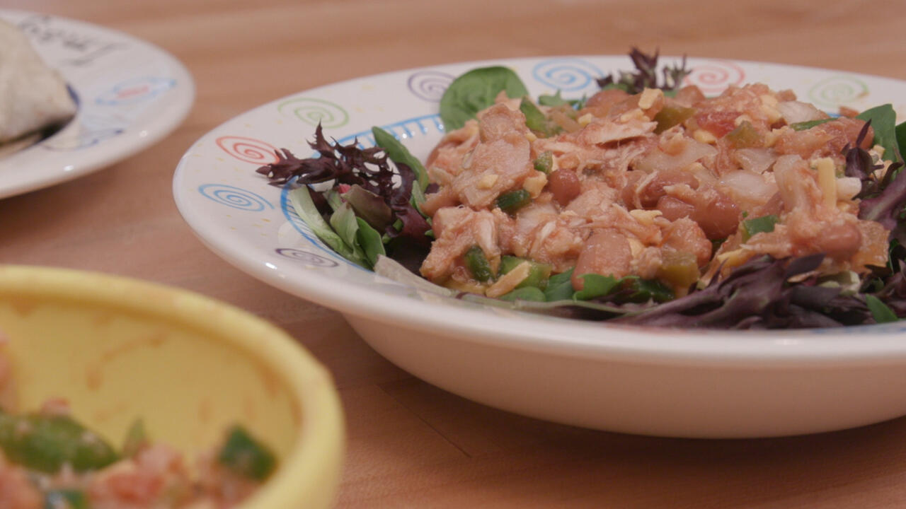 Spicy tuna on top of mixed greens, in a bowl as a dip, and in a wrap on a plate.