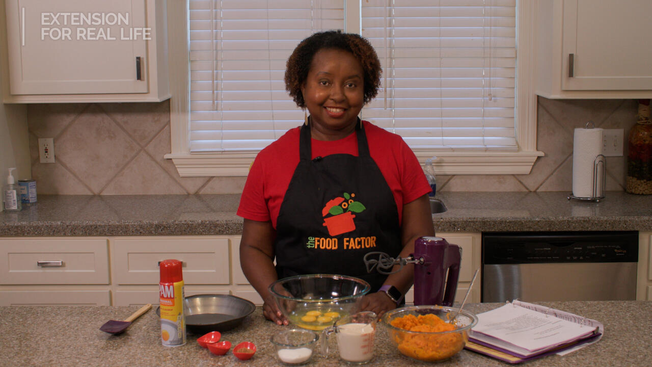 A woman at a kitchen counter with ingredients for a pie.