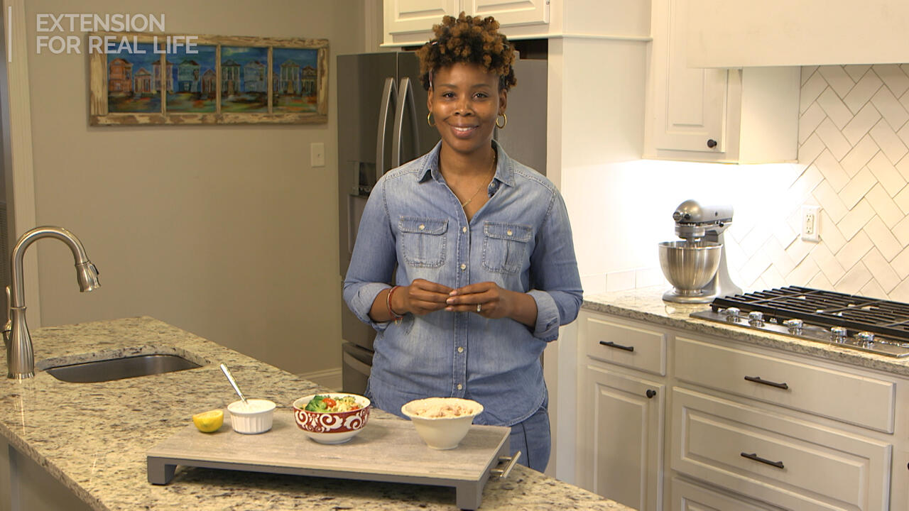 A lady stands in a kitchen.
