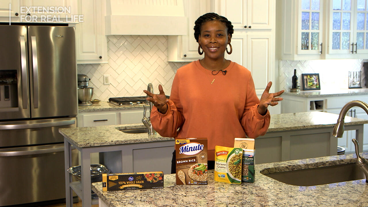 A woman stands at a kitchen counter with whole-grain products.